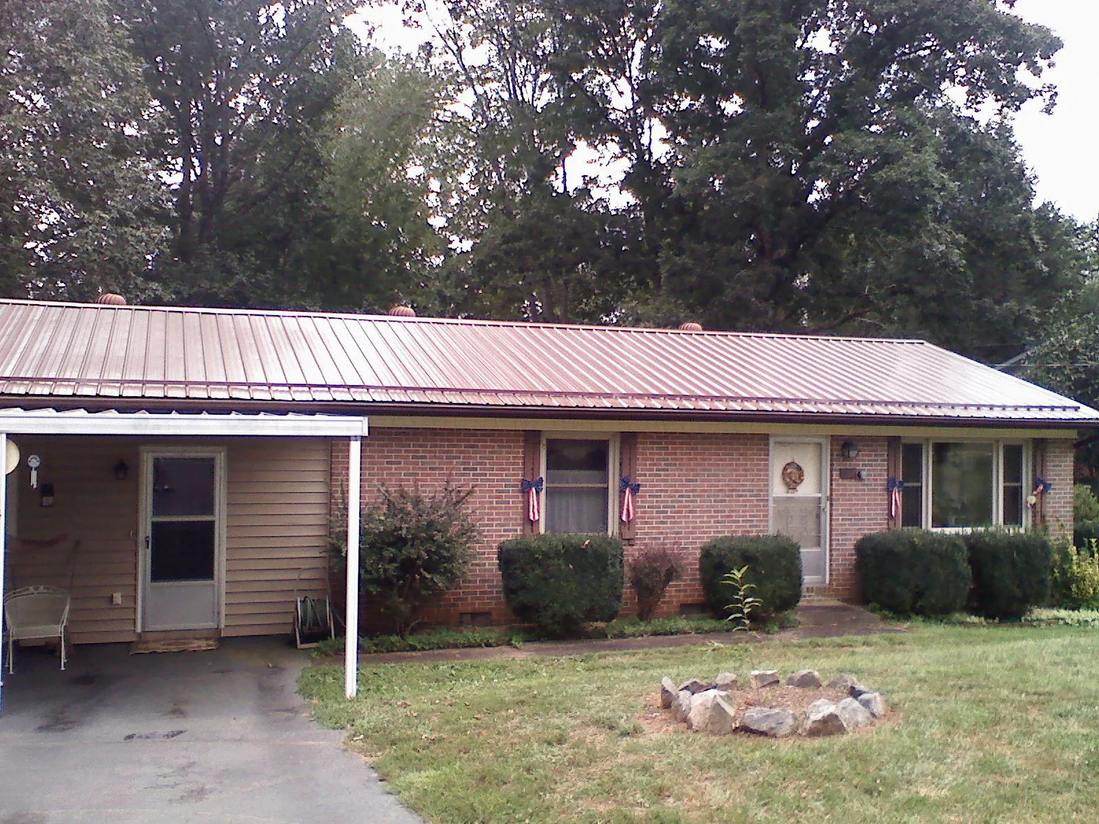 Bronze metal roof and carport on a brick ranch home — Roof Repair work by our crew in Gas City